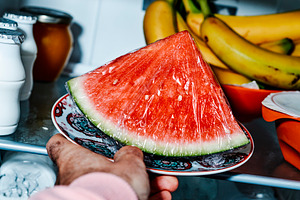 a man sets a plate with watermelon in the fridge, a Photo by Nito