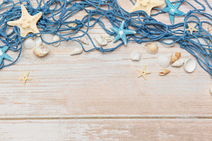 Fishing net, seashells, and starfishes creating a seaside border, a Holiday Photo by Olena Rudo