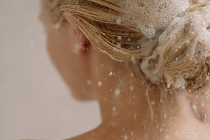 Woman washing blonde hair with shampoo and bubbles, showering for clean hygiene, a Photo by Studio ANNA