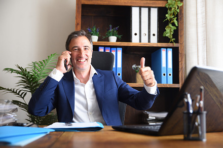 Businessman talking on the phone with ok sign in office, a Business Photo by Davizro's Market