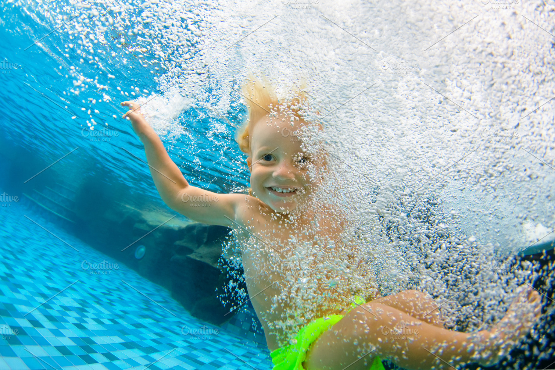 Funny little child dive underwater, a Person Photo by Tropical Studio