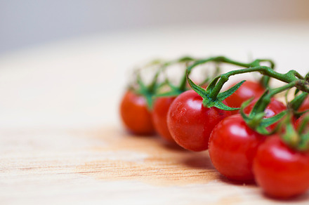 Some red cherry tomatoes containing small, closeup, and wood