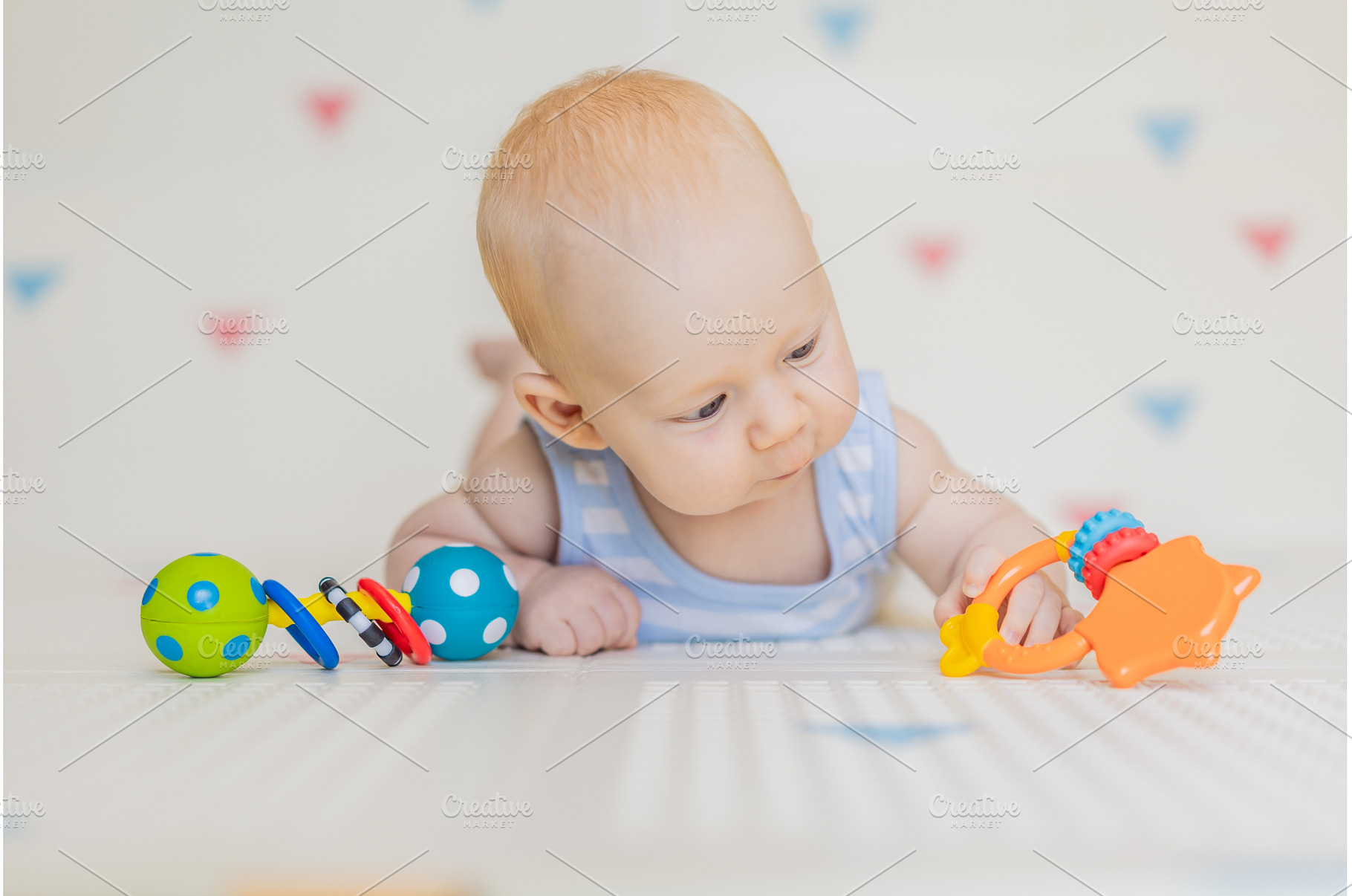 Adorable baby playing with colorful, a Background Photo by Elizaveta Galitskaya