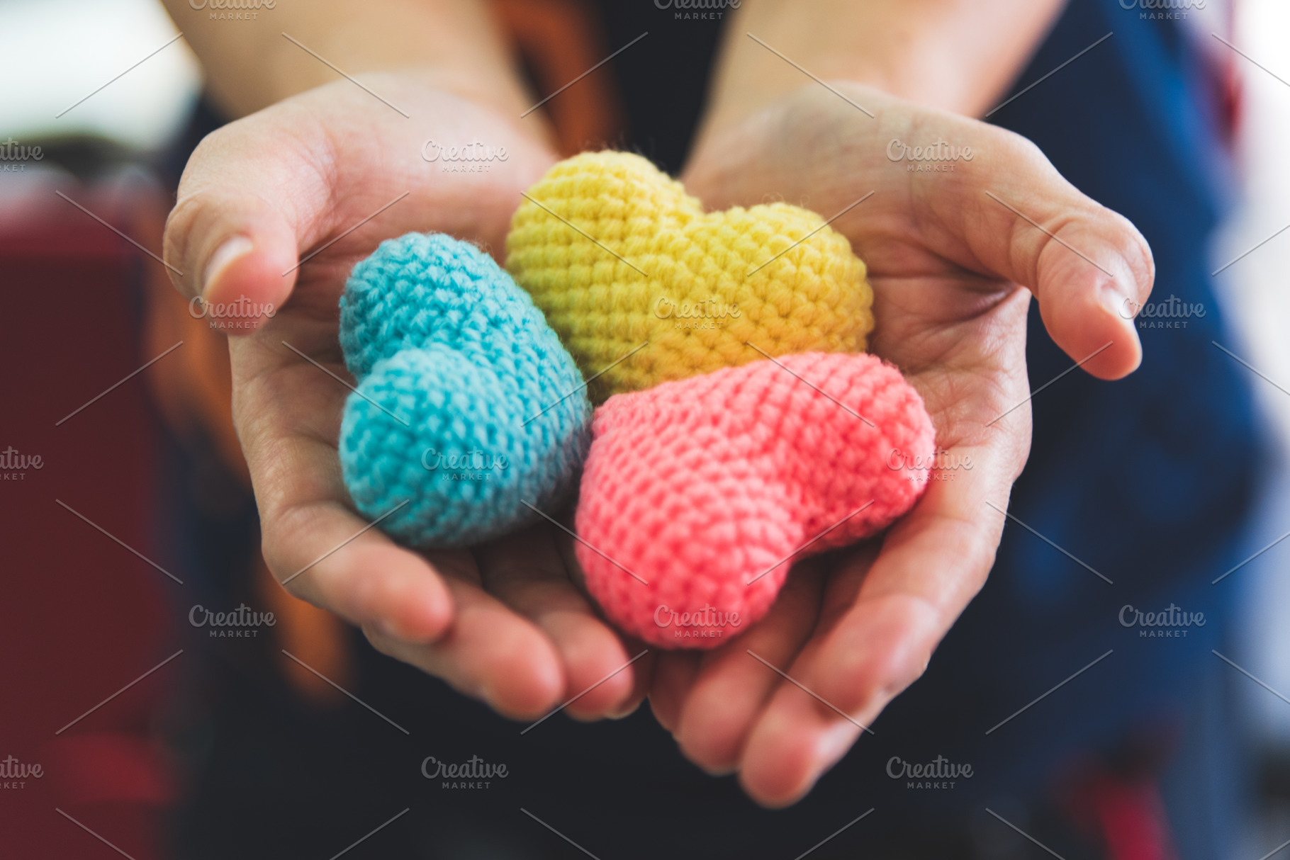 Close up hands giving colorful yarn heart handmade. Valentine da, a Person Photo by Ministocker