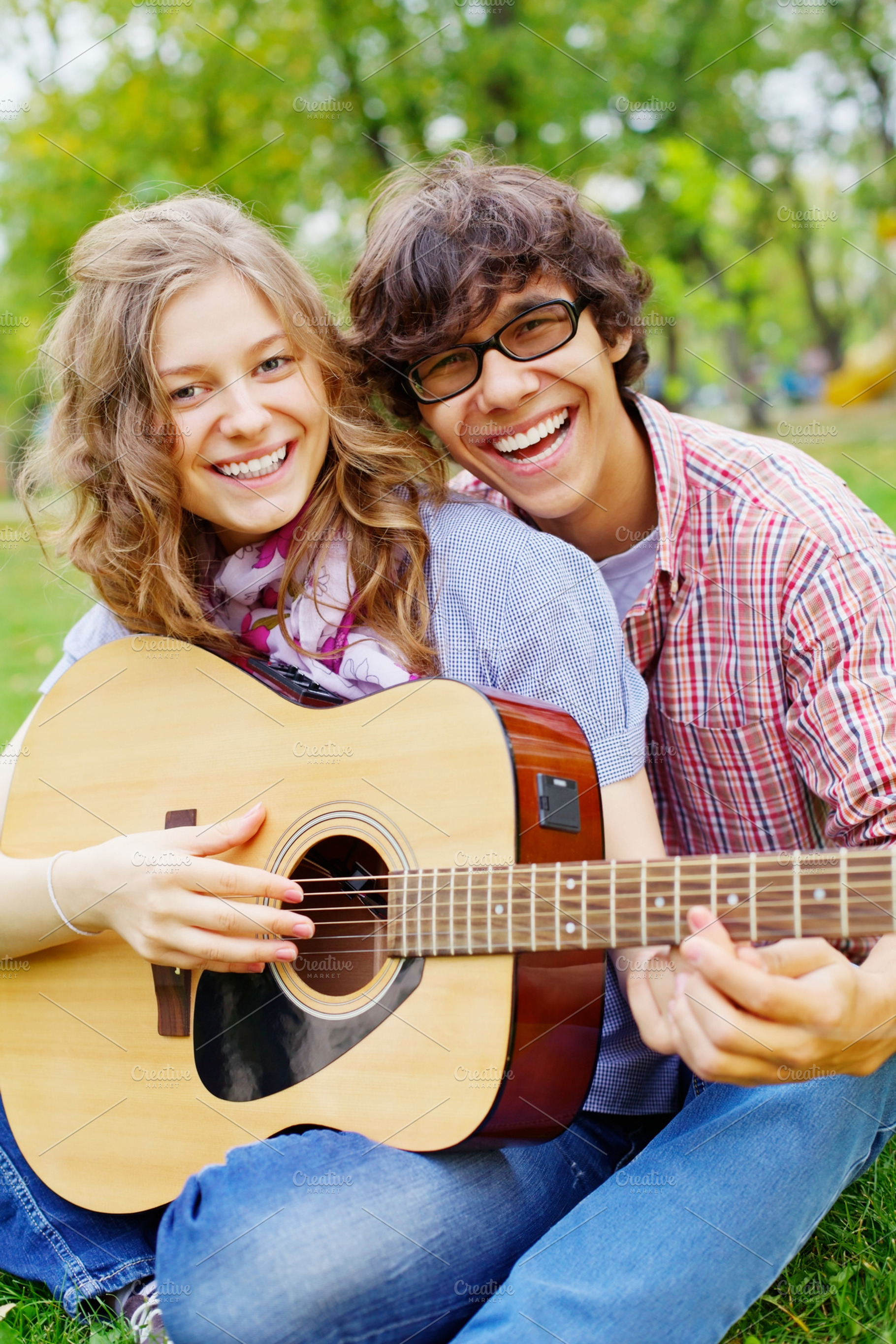 Teens with guitar in park