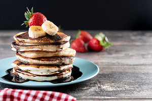 Pancakes with chocolate and fruit on wooden table, a Food & Drink Photo by etorres69