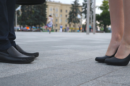 Businessman and businesswoman meeting at city street and greeting each other