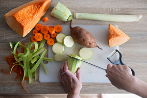 Top view of fresh vegetables being chopped on cutting board in home kitchen, a Food & Drink Photo by etorres69