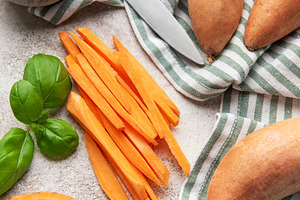 Preparing sweet potato fries with salt, basil, and a knife, a Food & Drink Photo by Olena Rudo