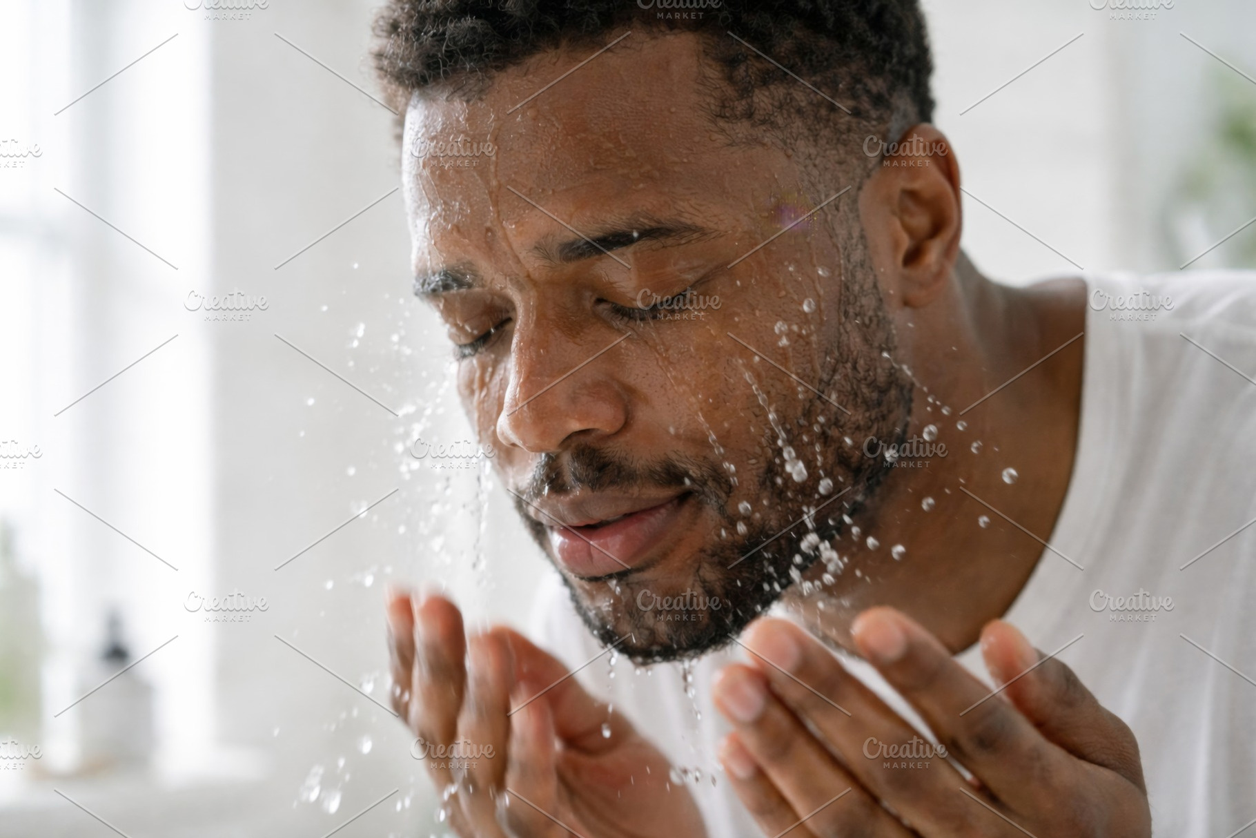 Man splashing water on face in self-, a Photo by Dvoevnore photos