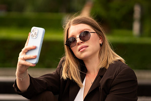 Woman sitting on bench, holds phone, a Person Photo by Elena Vagengeim