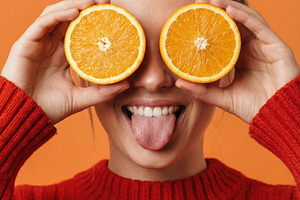 Playful Young Woman Holding Orange, a Person Photo by Virgo Studio
