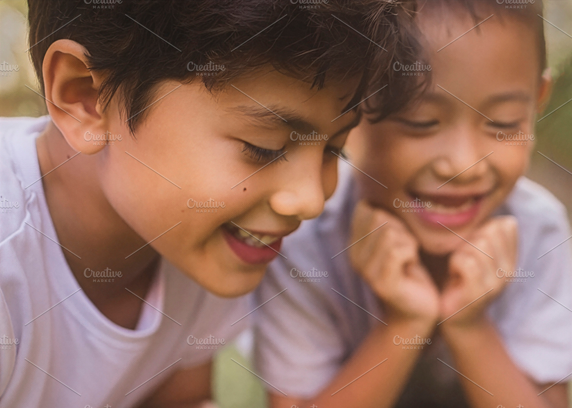 Children lying on grass watching gecko, a Person Photo by DanFLCreativo