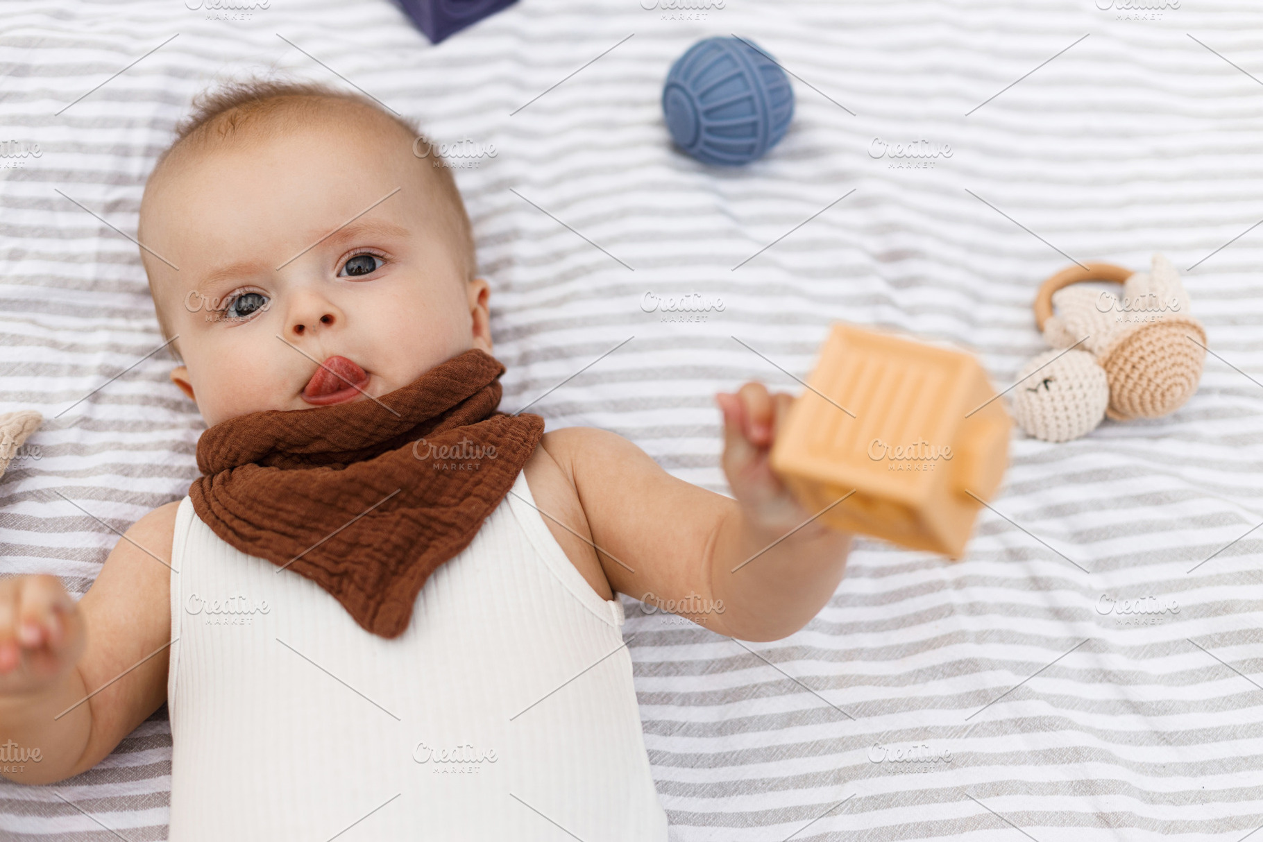 Beautiful happy baby lying on blanket and playing with toys in s, a Person Photo by Sonjachni