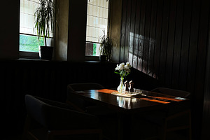Cozy dining table beside large windows in a warmly lit room, a Photo by AS photostudio