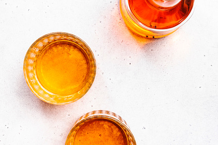 Scotch Whiskey glasses and bottle on white table background, cop, a Food & Drink Photo by 5PH