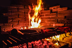 Barbecue fire cooking meat at night, a Food & Drink Photo by DanFLCreativo
