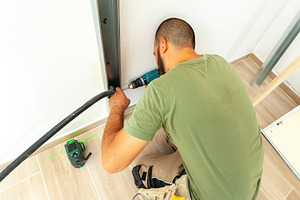 Electrician installing corrugated pipe for electrical wiring in plasterboard wa, an Industrial Photo by Antonio Gravante Market