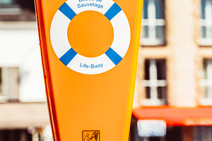 Life buoy in bright orange container, a Photo by Dvoevnore photos