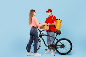 Courier Man Delivering Cardboard Box To Lady Over Blue Background, a Photo by Prostock-Studio