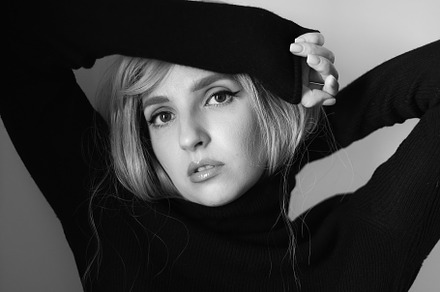 Close up portrait of a woman with pink hair and a black sweater on background i, a Person Photo by SaulichPhoto