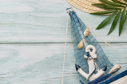 Seashells, sunglasses, straw hat, starfish and decorative sailbo