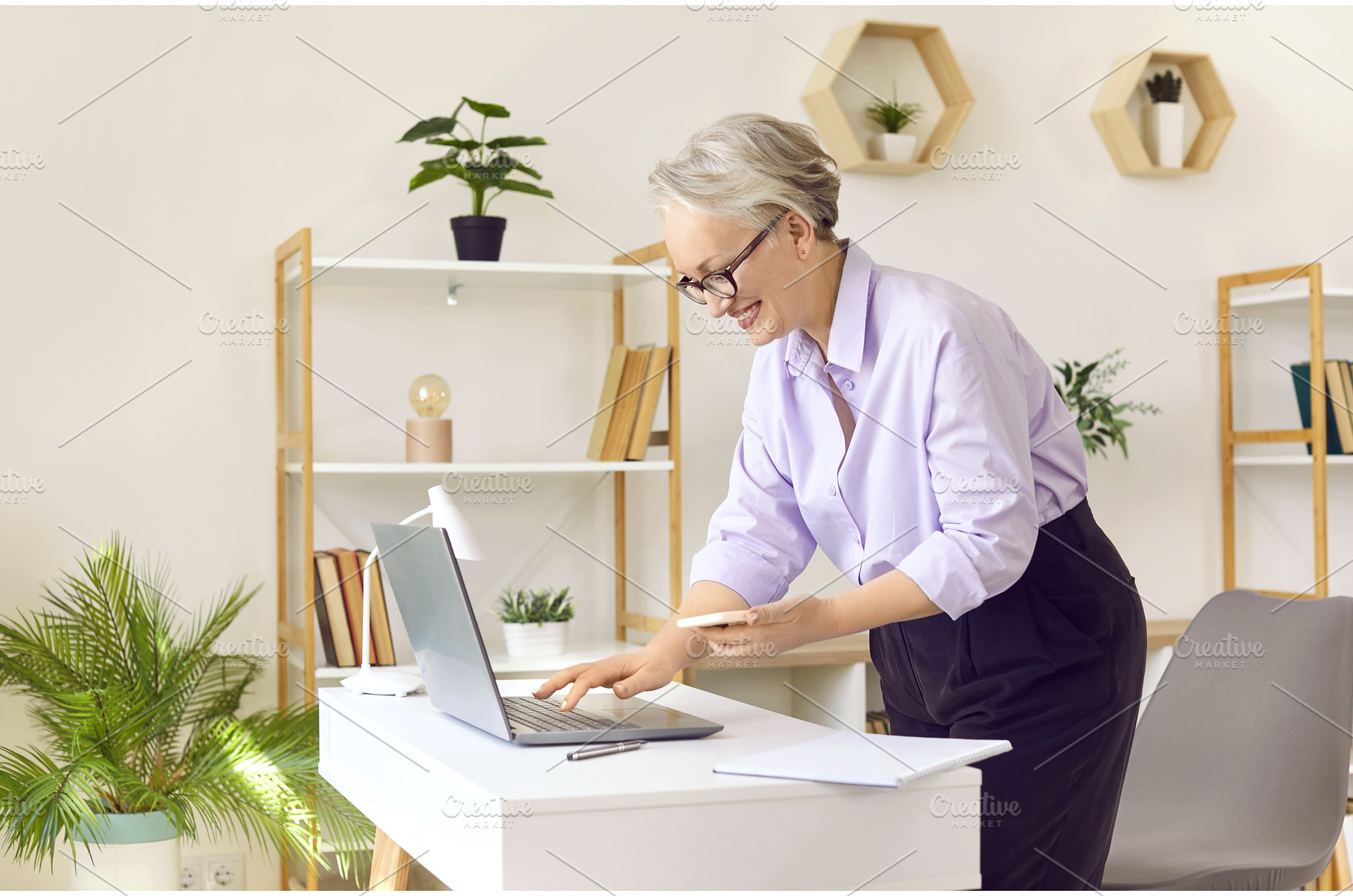 Joyful senior business woman reading, a Person Photo by StudioRomantic