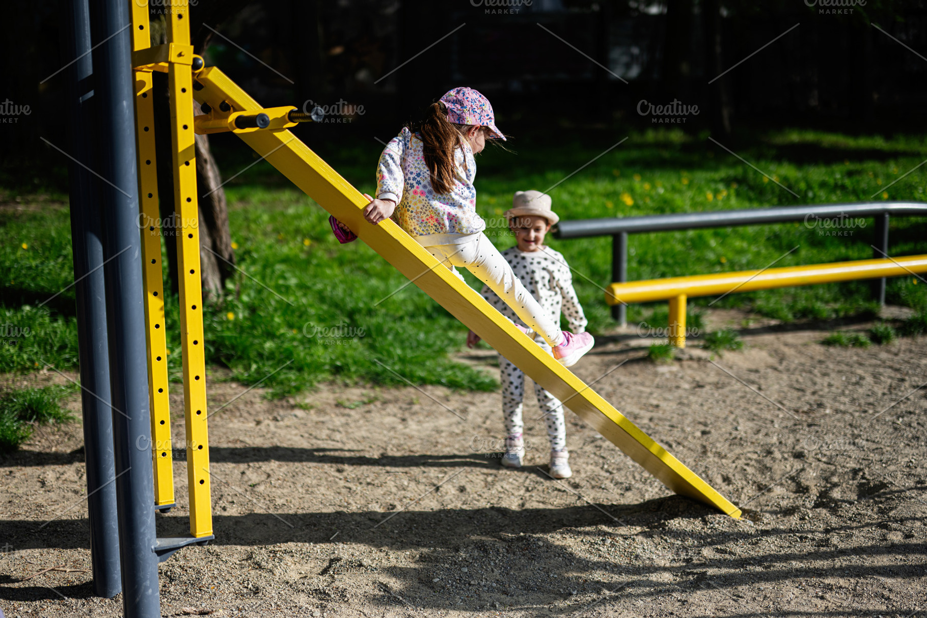 Kids playing on colorful equipment at a sunny outdoor playground, a Person Photo by AS photostudio
