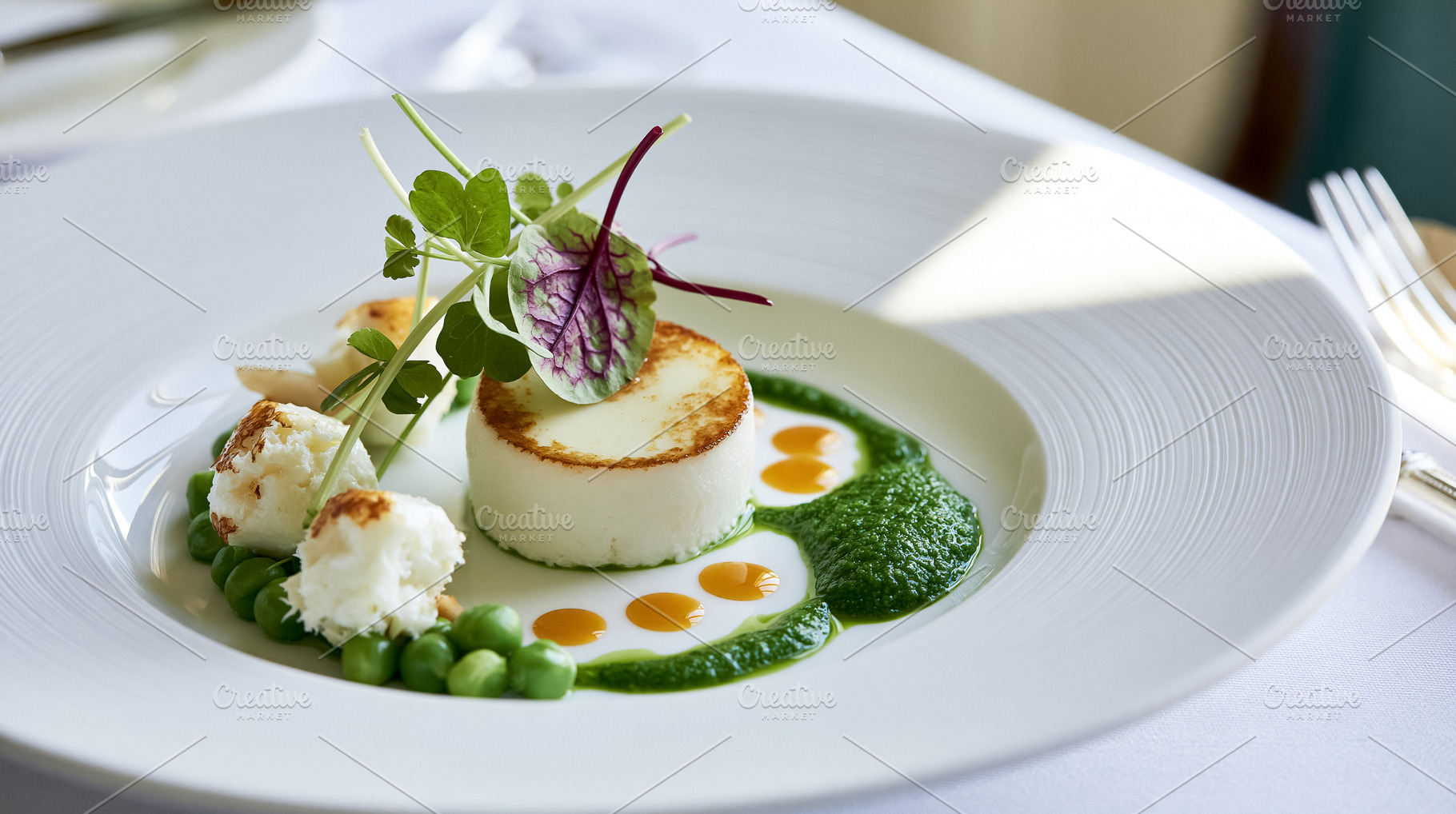 Gourmet appetizer with seared goat cheese, green pea puree, celeriac foam, and, a Photo by Studio ANNA