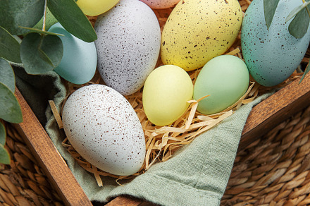 Easter decor. Colored Easter eggs in a wooden box on the table., a Holiday Photo by Olena Rudo