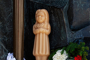 Wax devotional candle with flowers in sacred site in Fatima, Portugal, a Photo by AS photostudio