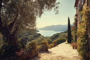 Old stone villa with green shutters overlooking a bay, featuring, a Photo by Studio ANNA