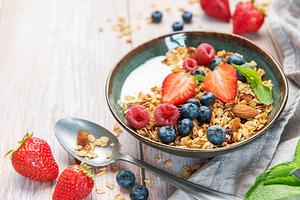 Healthy breakfast bowl with granola and fresh berries, a Food & Drink Photo by Olena Rudo