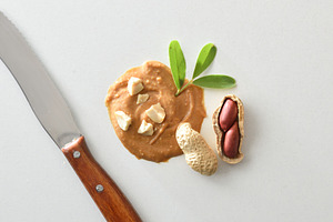 Macro background of peanut butter with knife pieces and fruits, a Food & Drink Photo by Davizro's Market