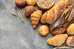 Assortment of fresh bread and pastries on gray background, a Food & Drink Photo by Olena Rudo