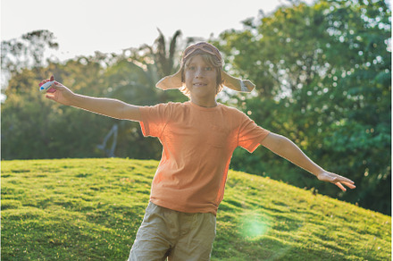 Boy wearing a pilot hat running