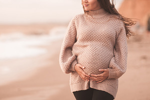 Pregnant woman outdoors featuring pregnancy, prenatal, and care