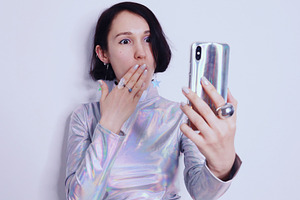 Surprised girl looks at the iPhone