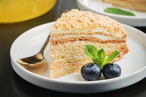 Medovik. Honey cake made from honey cakes with whipped sour cream, decorated wi, a Food & Drink Photo by Budarinphoto