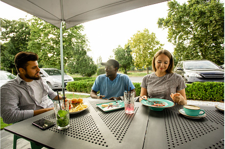 Group of multiracial friends eating, a Person Photo by oksix