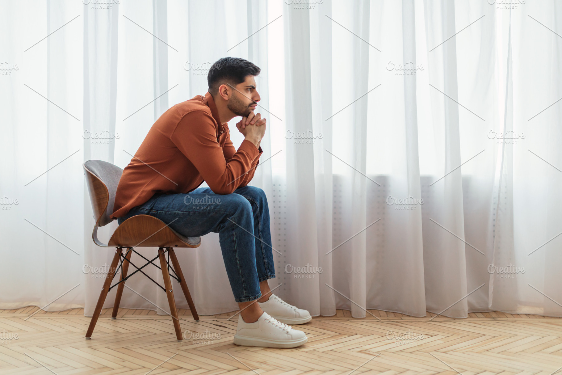 Pensive Arab man sitting on chair and thinking, a Photo by Prostock-Studio