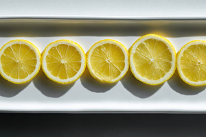 Lemon slices arranged on tray, a Photo by Virgo Studio