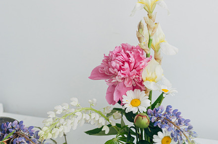 Modern summer flowers composition on rustic white table indoors., a Nature Photo by Sonjachni