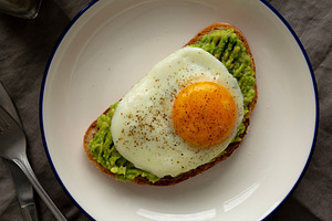 Homemade Avocado Toast with Egg on a Plate, top view., a Food & Drink Photo by LiudmylaChuhunova