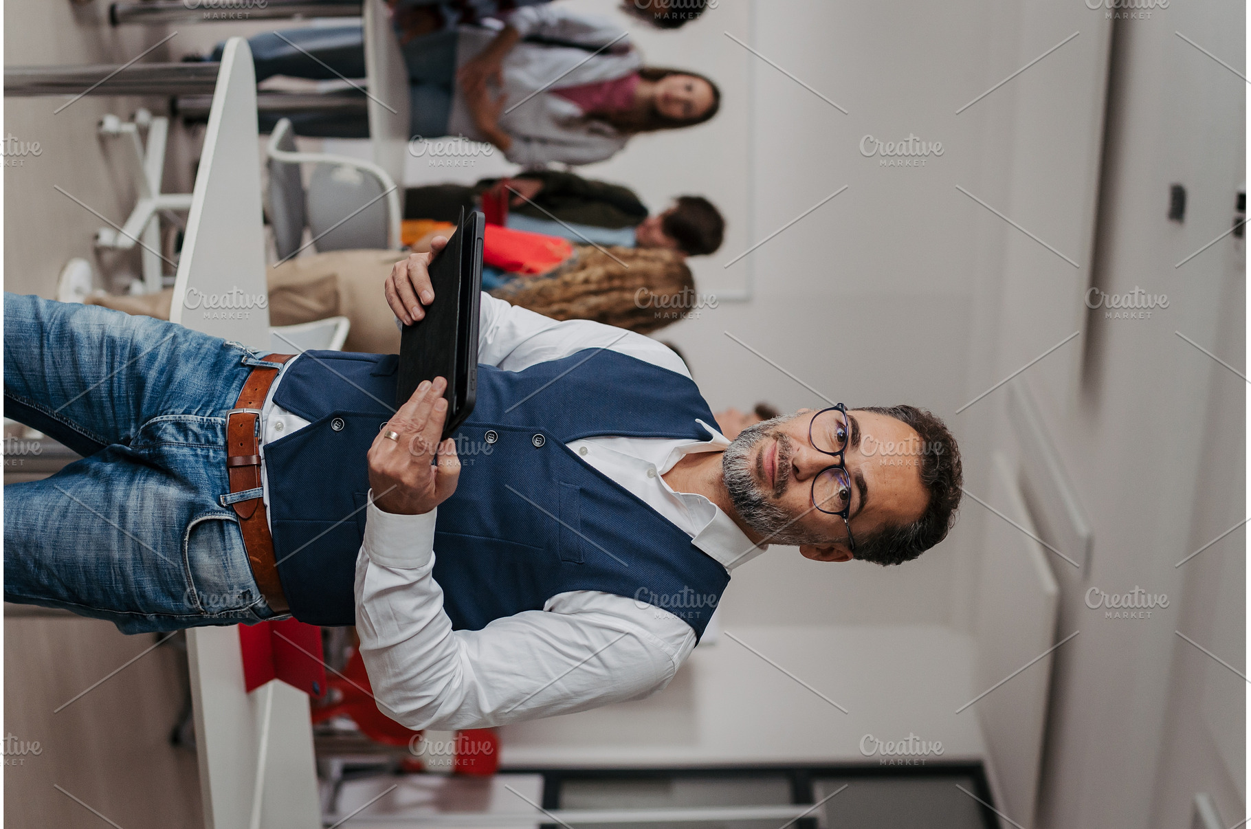 Teacher holding a tablet in modern, a School & Education Photo by HalfPoint