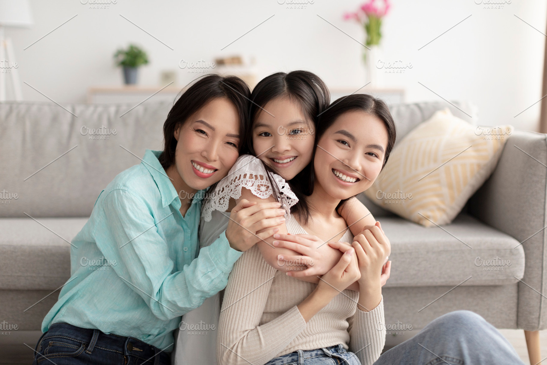 Young Asian woman with her cute daughter and mature mother hugging and smiling, a Photo by Prostock-Studio