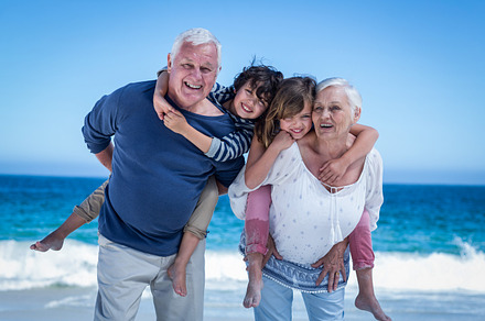 Happy grandparents giving piggy back to children, a Photo by wavebreak