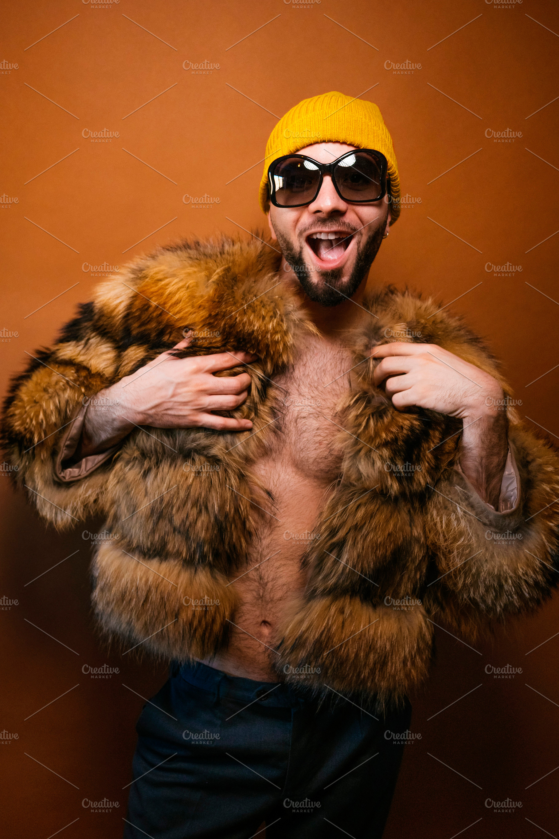Gay man expressing joy and self-confidence in fur coat, a Photo by karrastock