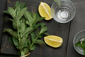 Bunch of fresh green mint, lime slices, glasses, top view. Cockt, a Food & Drink Photo by ndanko