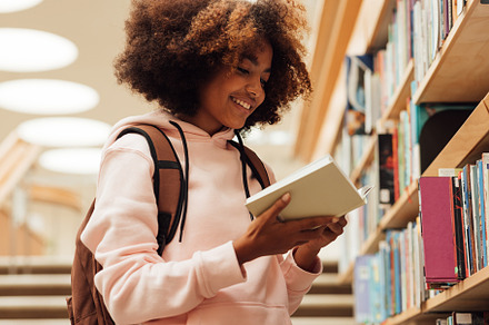 Smiling girl holding a book, a School & Education Photo by Artem Varnitsin